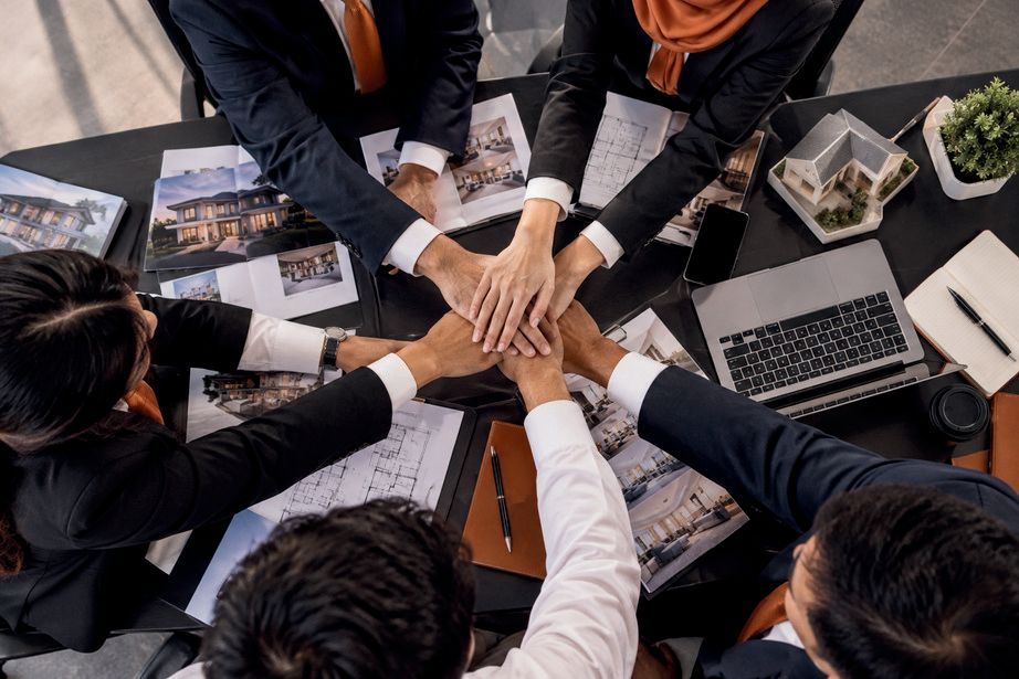 VIKS team members joining hands over a meeting table